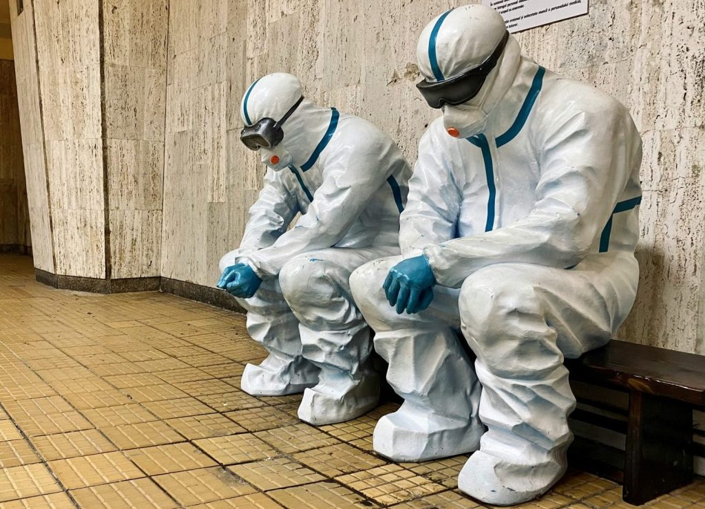 three people in white suits sitting on a bench